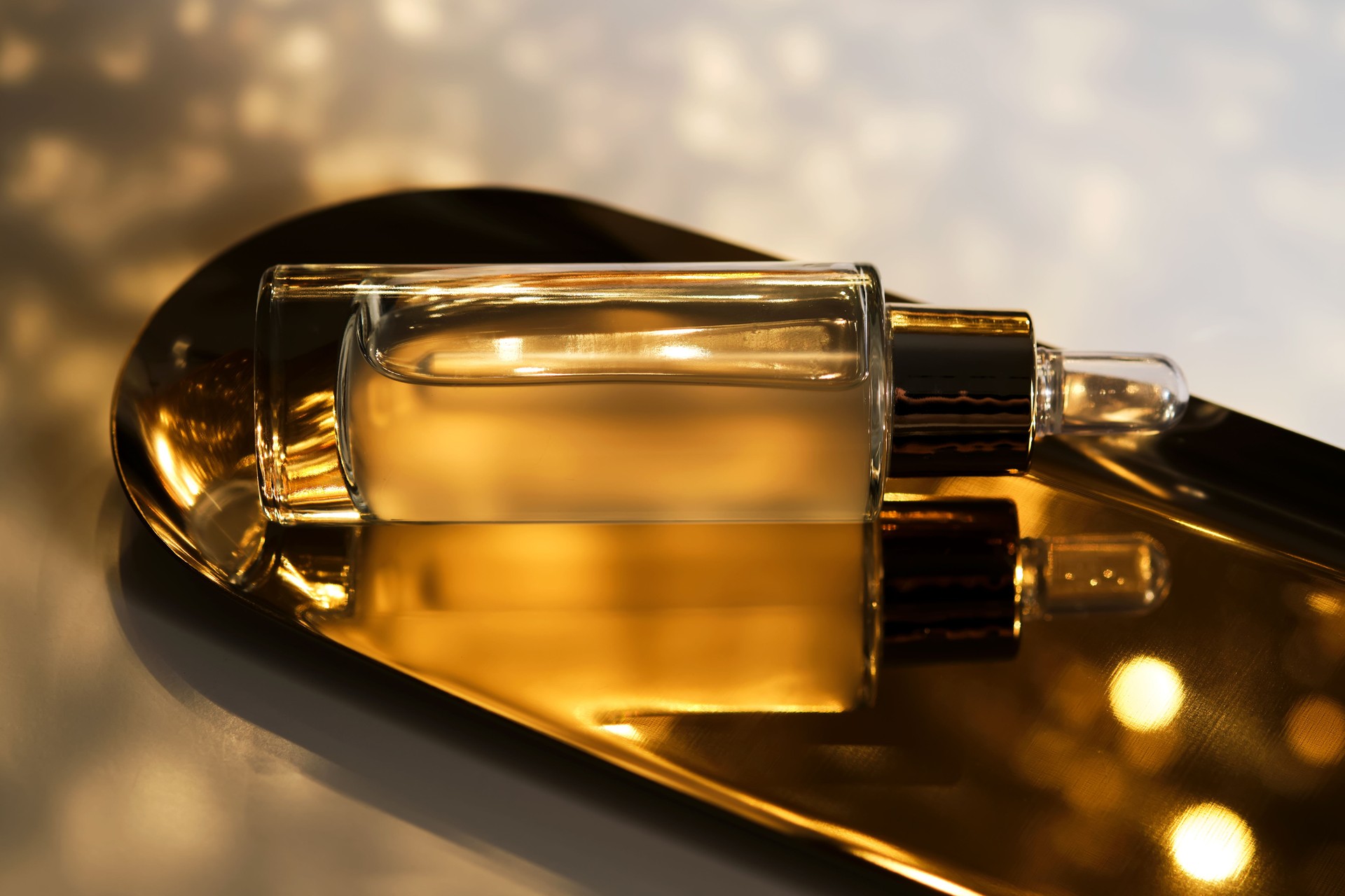 A bottle of cosmetic serum with a pipette on a festive golden background. A bottle of cosmetic serum with a pipette on a festive golden background.